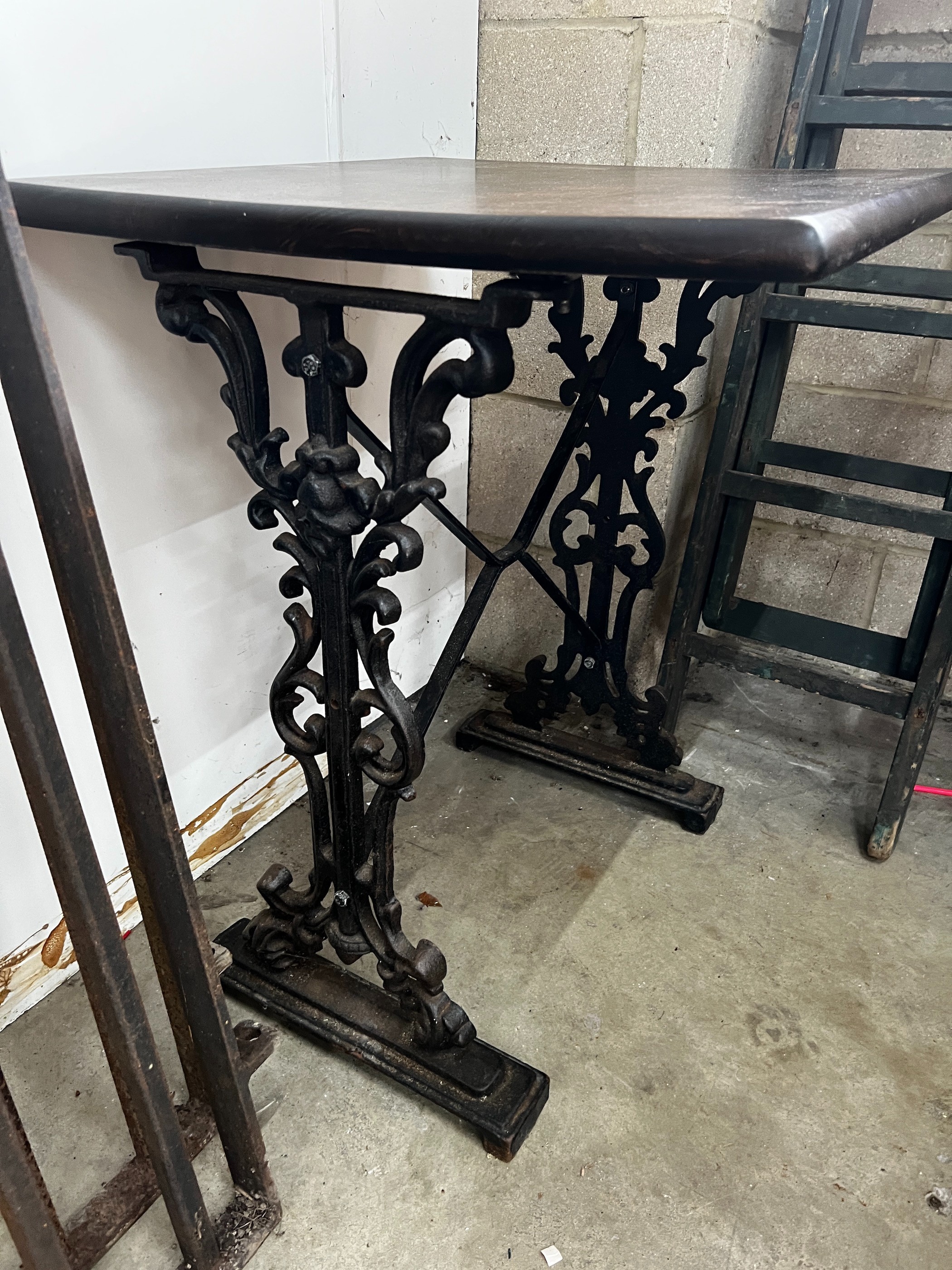 Two Victorian style cast metal stained wood topped tavern tables, larger width 120cm, depth 60cm, height 75cm